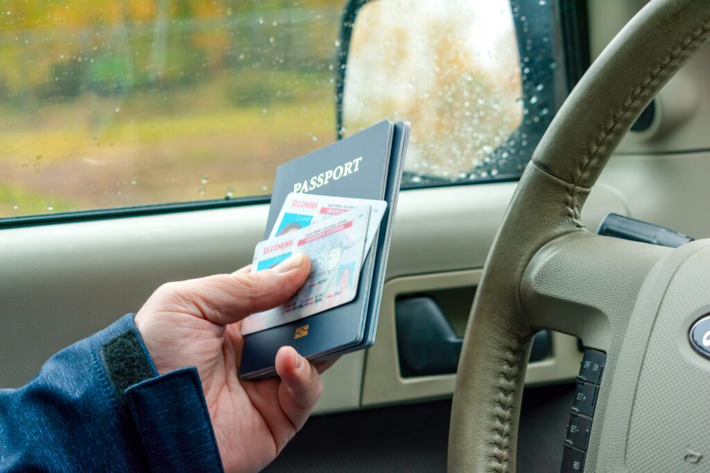 Man in car providing passport and identification at customs checkpoint